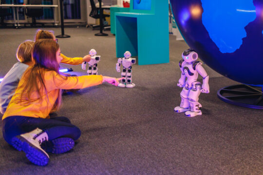 Otrok se igra z robotom v Tehnopark Celje.